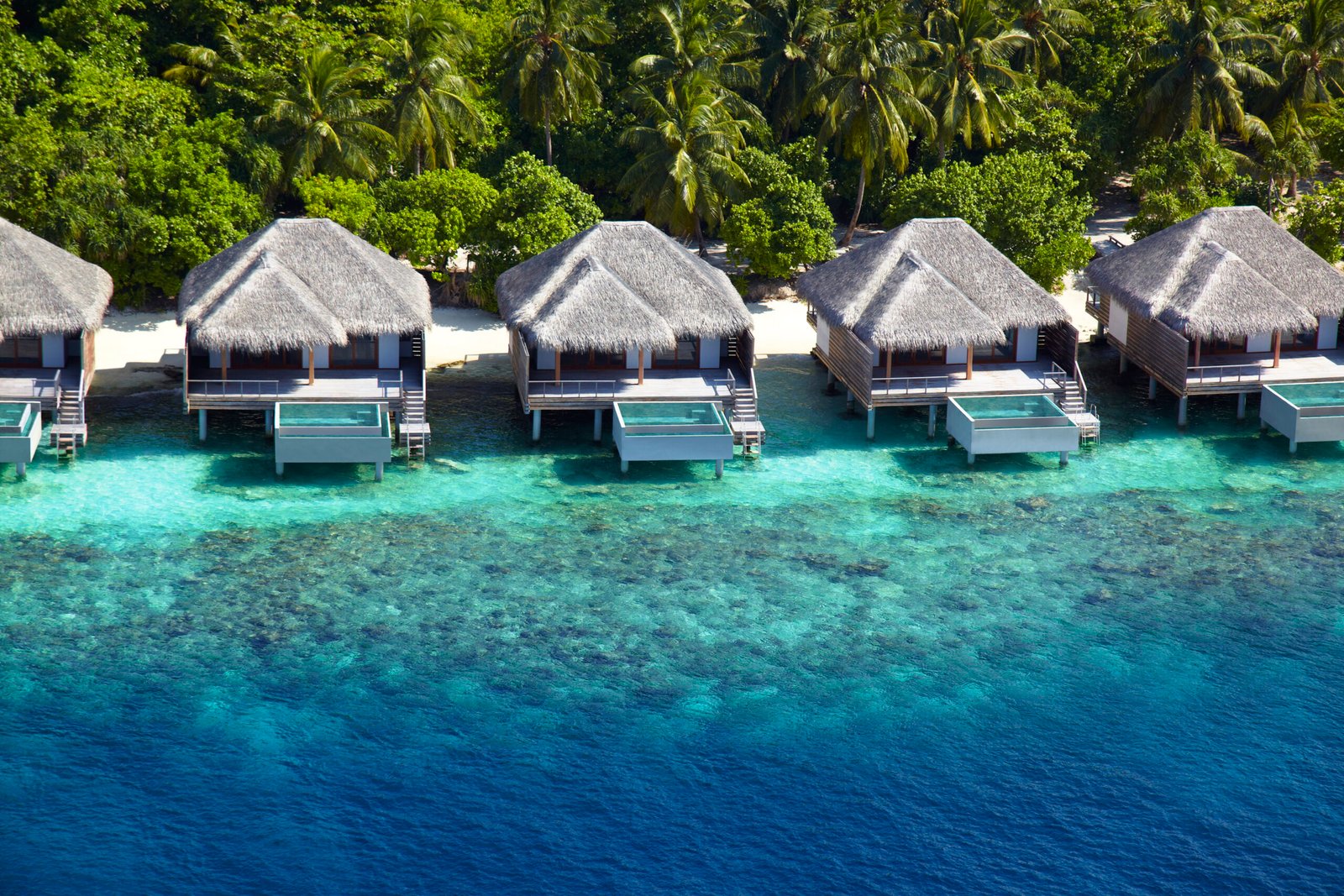 Turquoise lagoon and overwater villa row at Dusit Thani Maldives, Baa Atoll