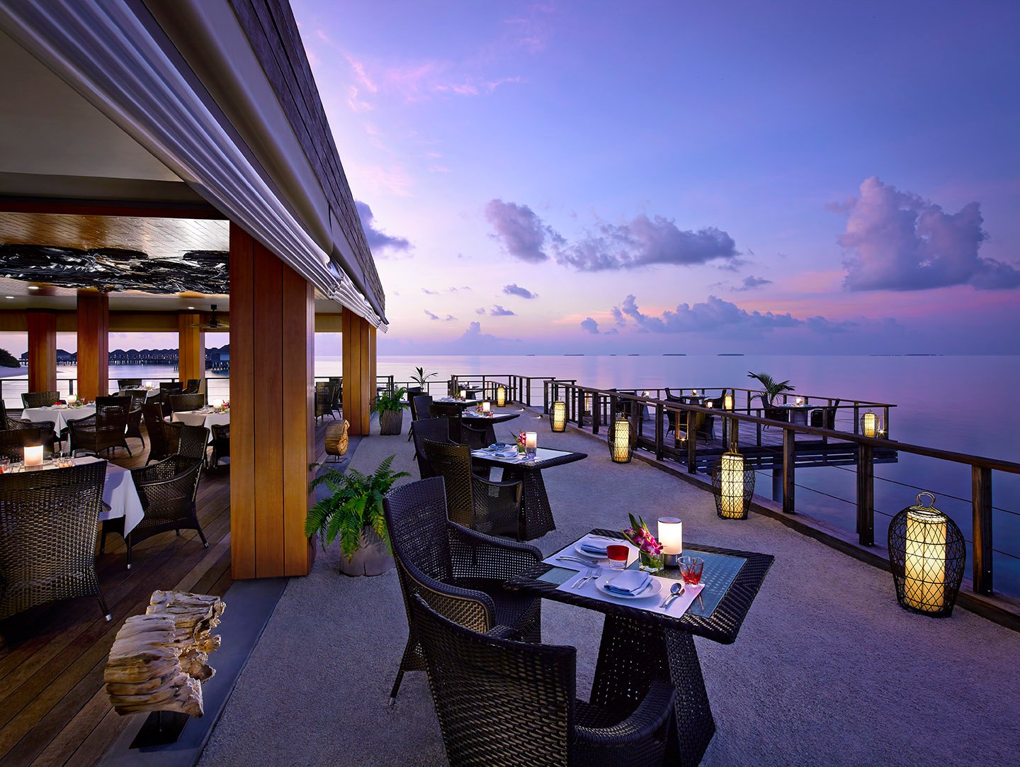 Benjarong overwater restaurant terrace at dusk, Dusit Thani Maldives