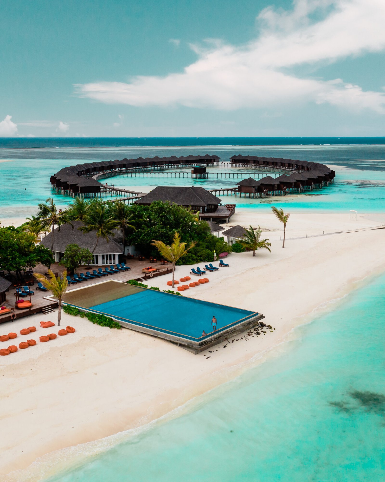 Aerial view of the circular water villa jetty, infinity pool and beach at Sun Siyam Olhuveli, Maldives