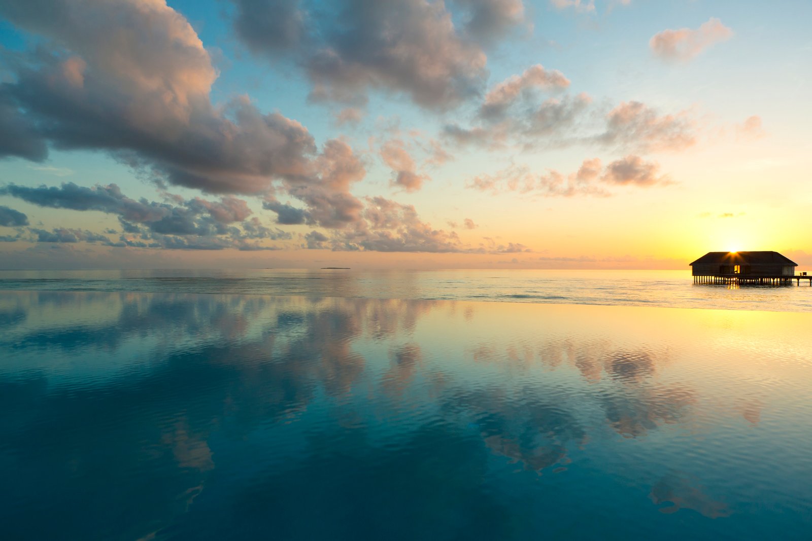 Sunset over an overwater villa, Dusit Thani Maldives