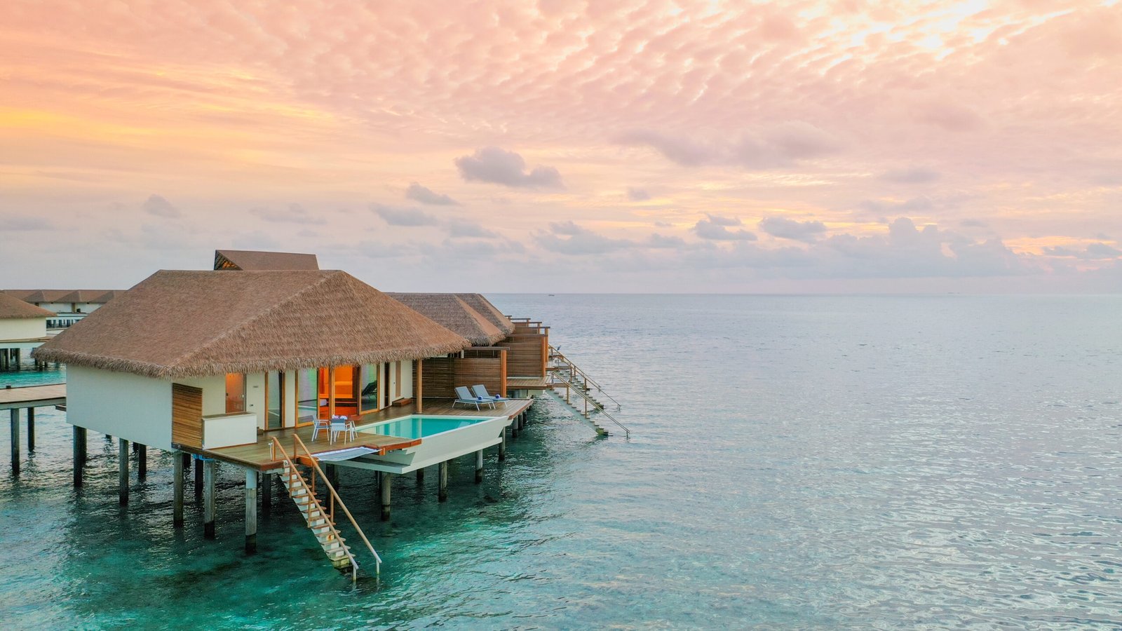 Sunset over an overwater villa pool deck, Cinnamon Velifushi Maldives