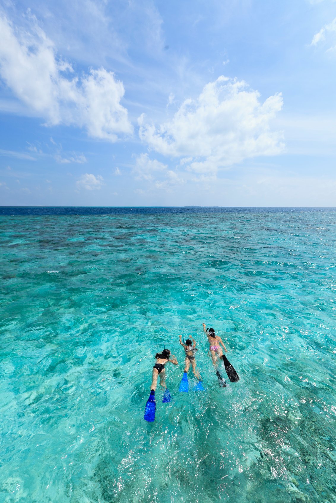 Family snorkelling together, Dusit Thani Maldives house reef