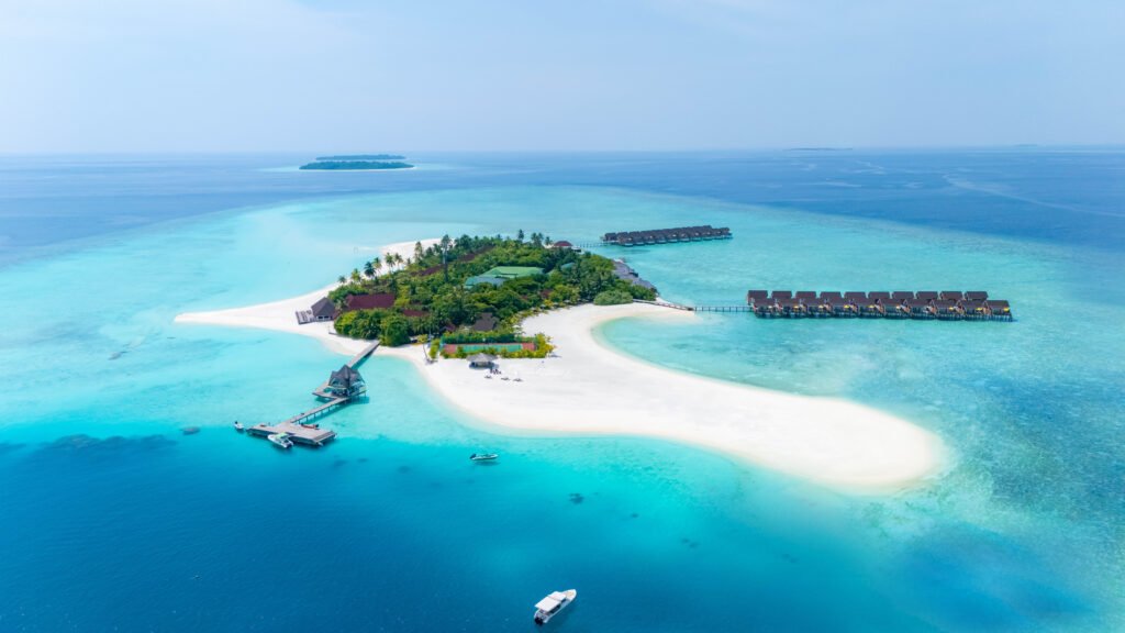 Dhigufaru Island Resort hero — aerial view of the island, Baa Atoll, Maldives
