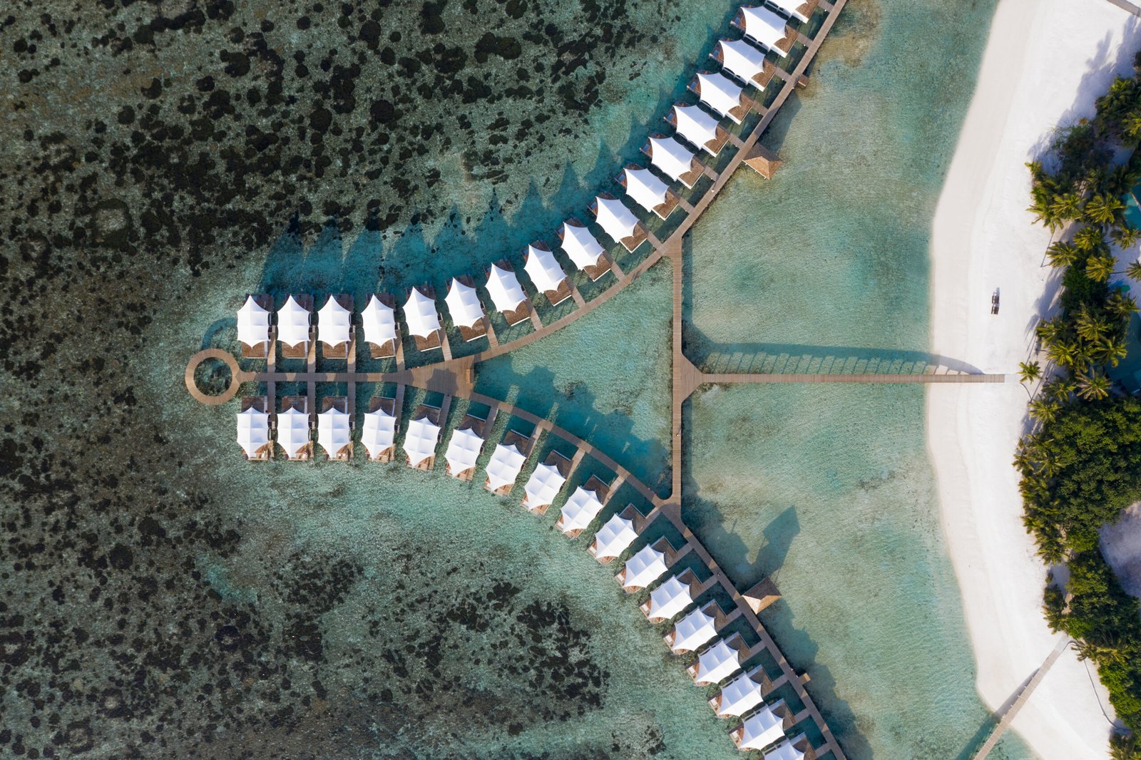 Aerial view of the overwater bungalow jetties, lagoon and reef pattern, Cinnamon Hakuraa Huraa Maldives, Meemu Atoll