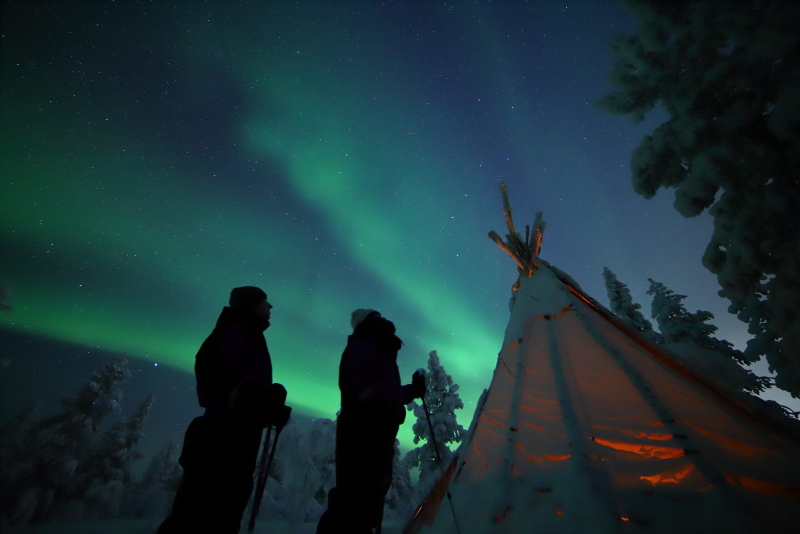 Snowshoe tour under the aurora near a traditional lávvu-style tent, Northern Lights Village Saariselkä