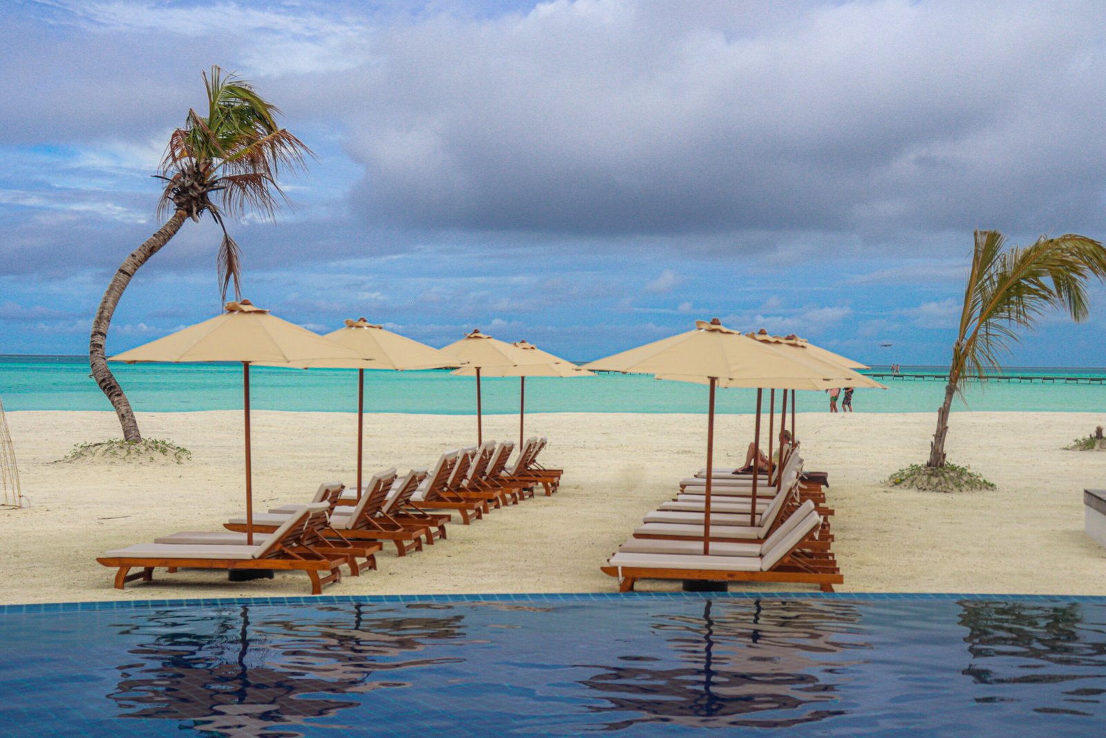 Poolside sun loungers and beach, Cinnamon Hakuraa Huraa Maldives