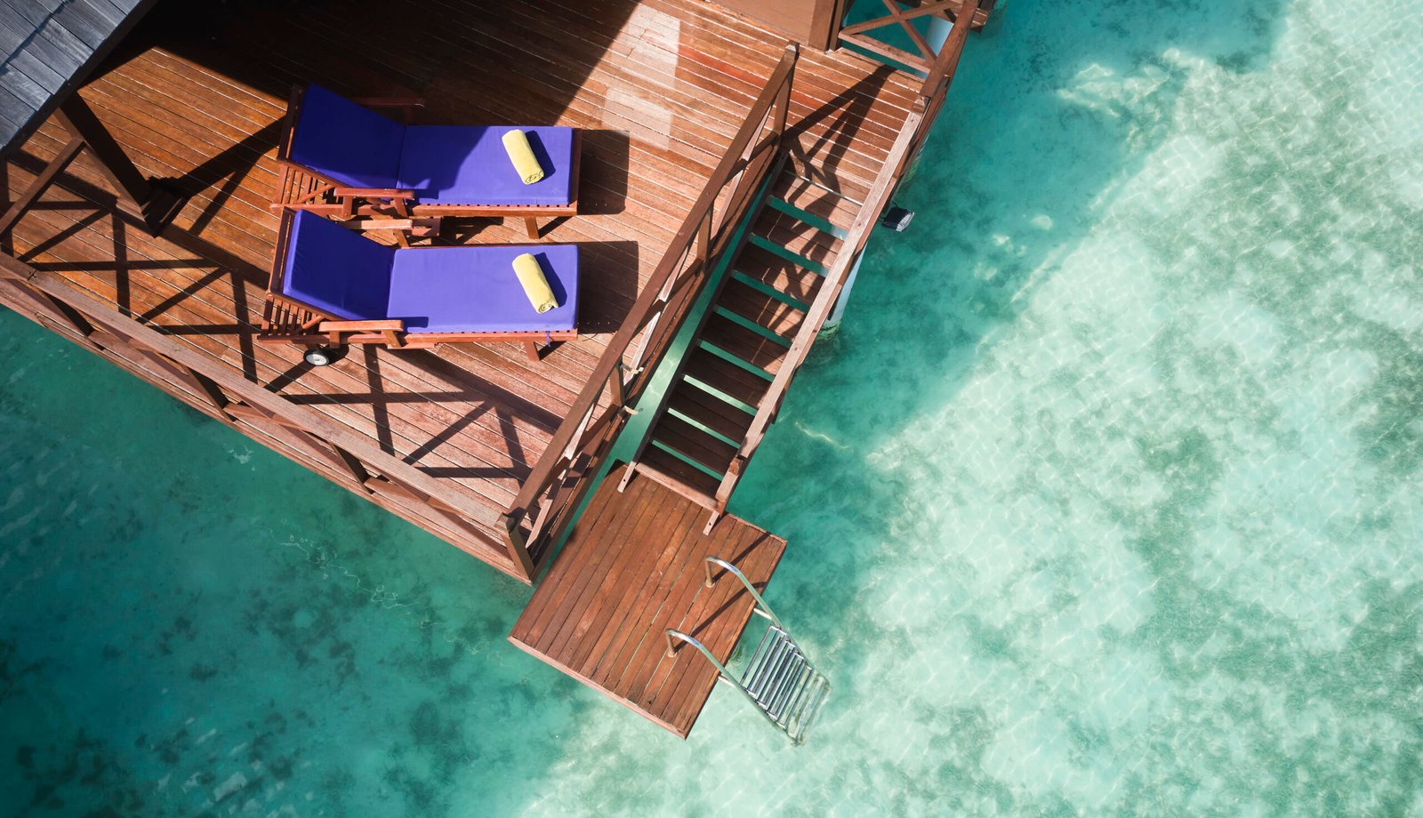 Overwater villa deck detail with loungers and water access, Sun Siyam Olhuveli