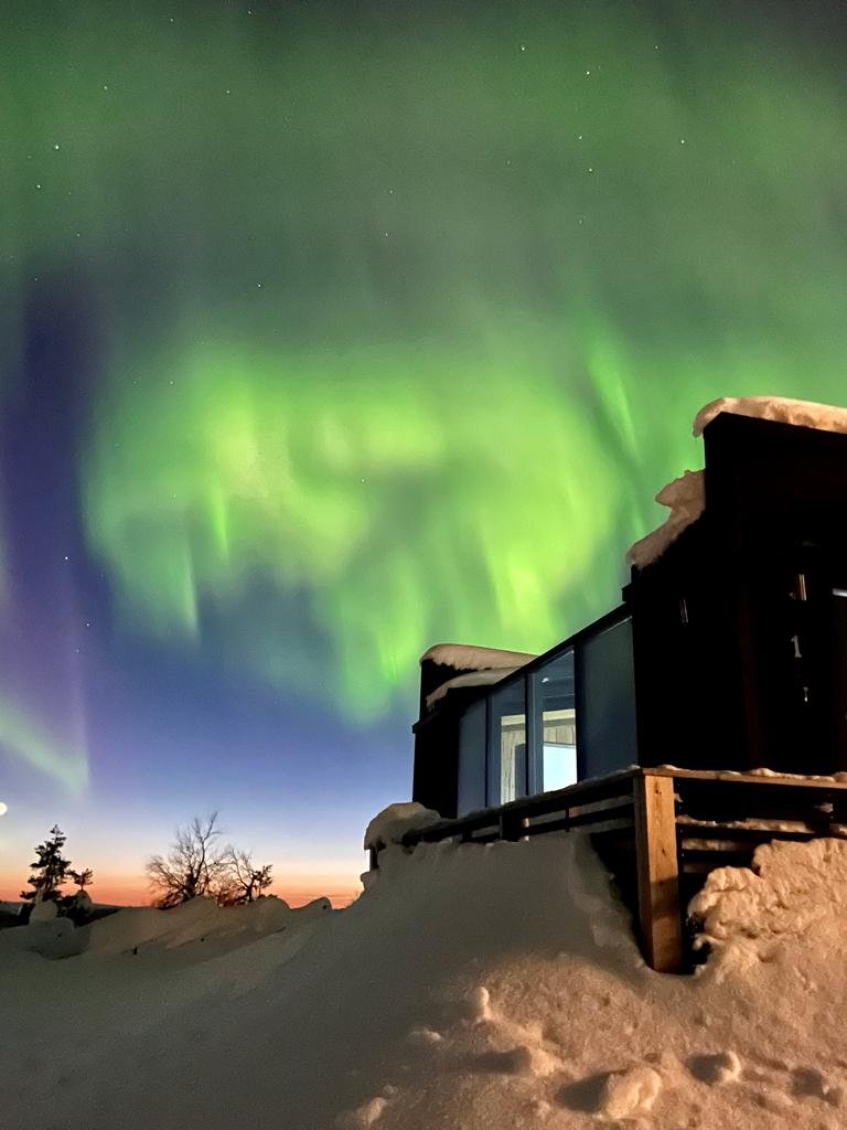 Aurora Cabin exterior under the northern lights, Northern Lights Village Saariselkä