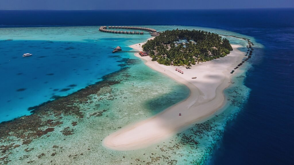 Sun Siyam Vilu Reef hero — aerial view of the island and overwater villa loop, Dhaalu Atoll, Maldives