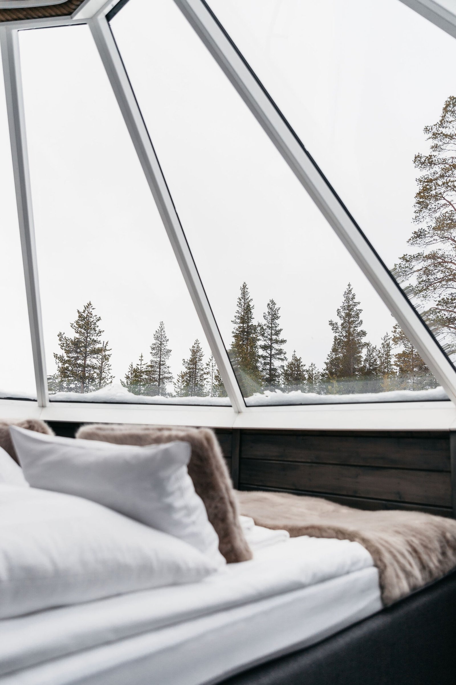 Aurora Cabin bed positioned beneath the partial glass roof, Northern Lights Village Saariselkä