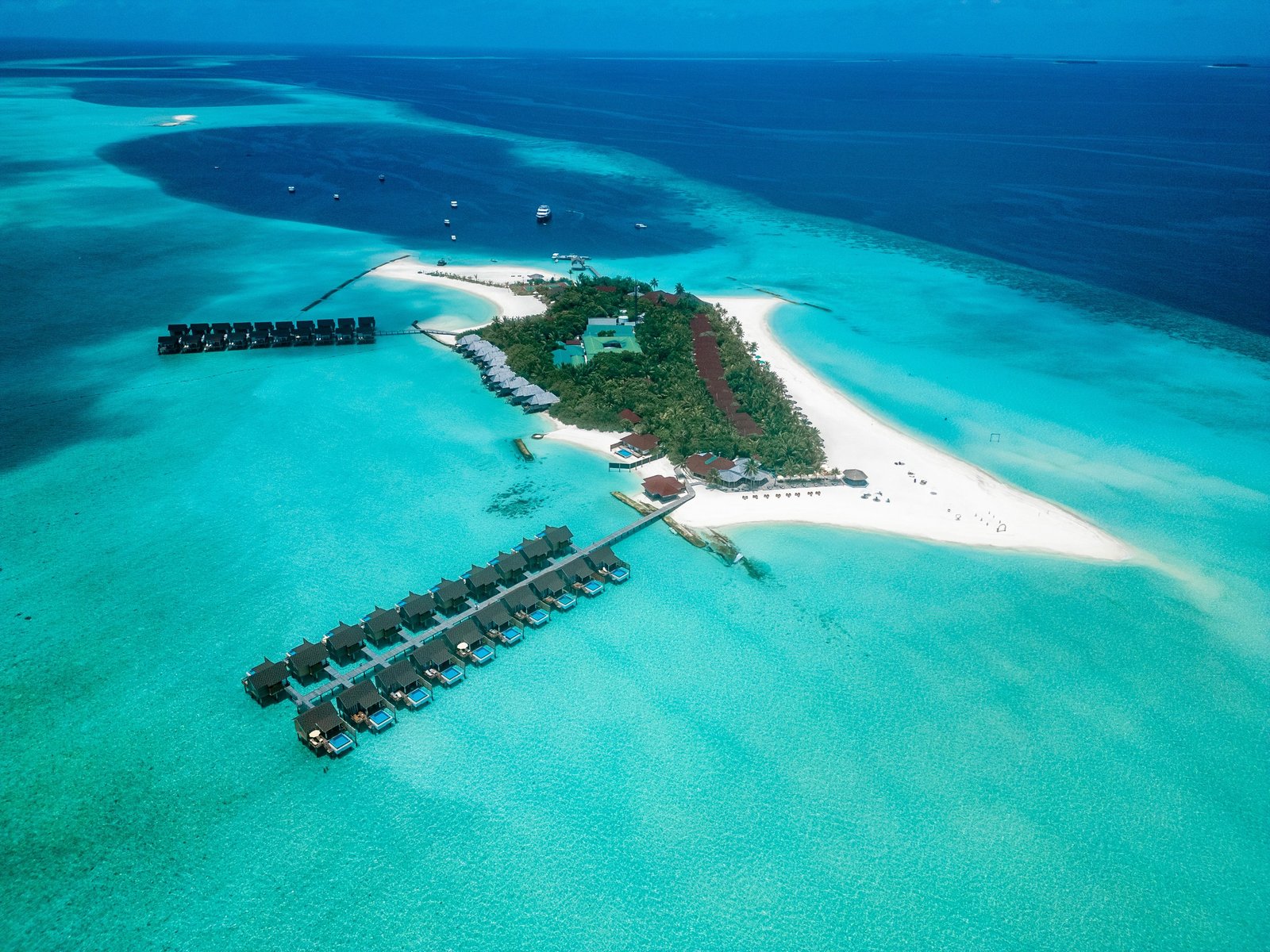 Dhigufaru Island Resort, its sandbank and overwater villa rows from the air, Baa Atoll