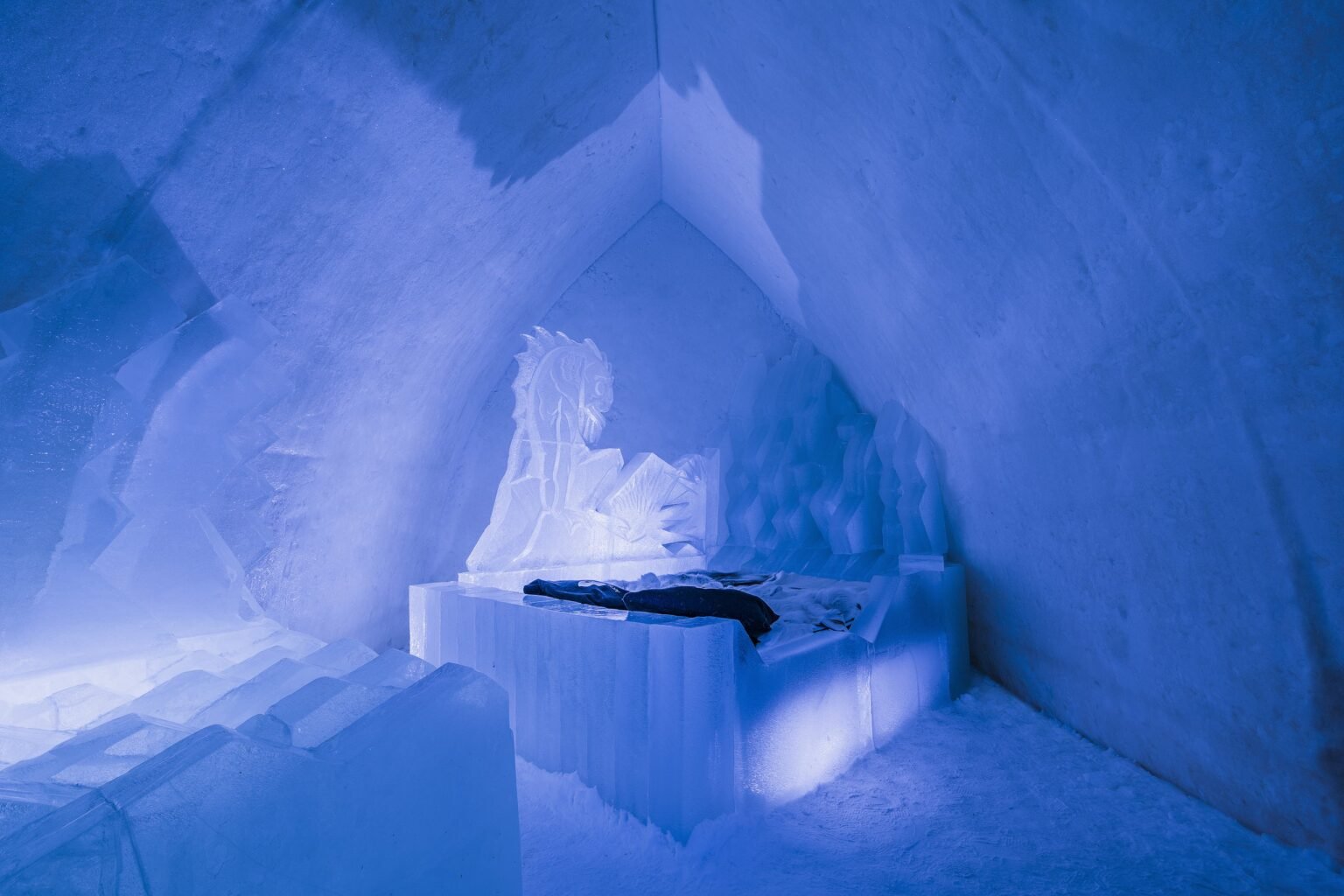 A room carved from snow, kept between 0 and −5 °C — Arctic SnowHotel & Glass Igloos, Sinettä, Rovaniemi