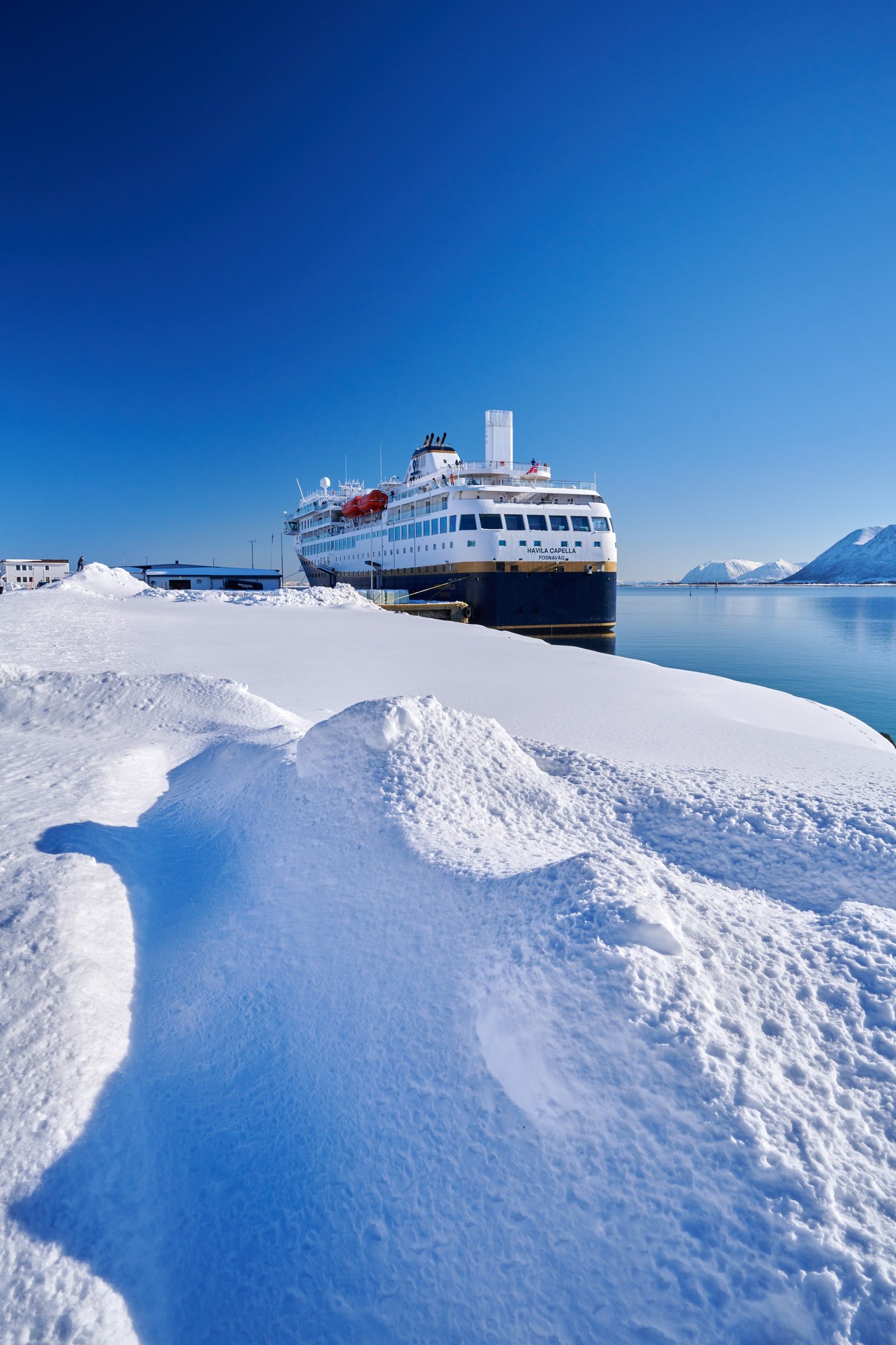 A Havila Voyages ship in winter ice on the Norwegian coast