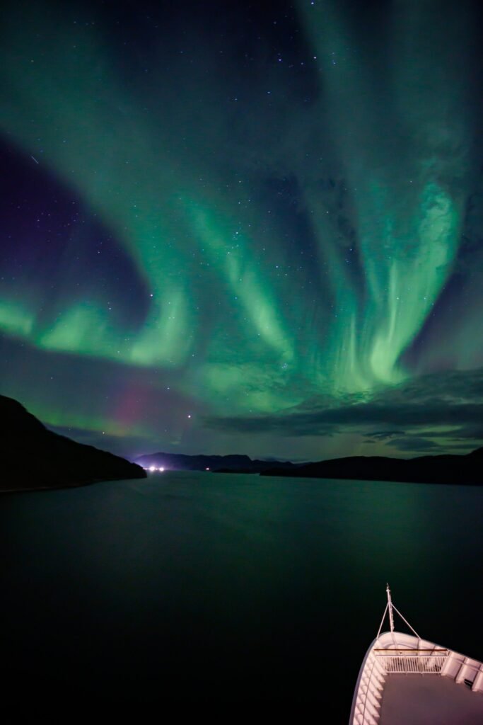 The northern lights over the Norwegian coast, seen from the bow of a Havila ship