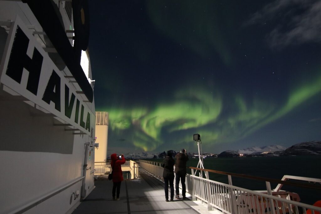 A guest photographing the northern lights from the deck
