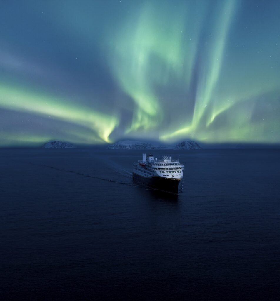 A Havila ship under the northern lights on the Norwegian coast