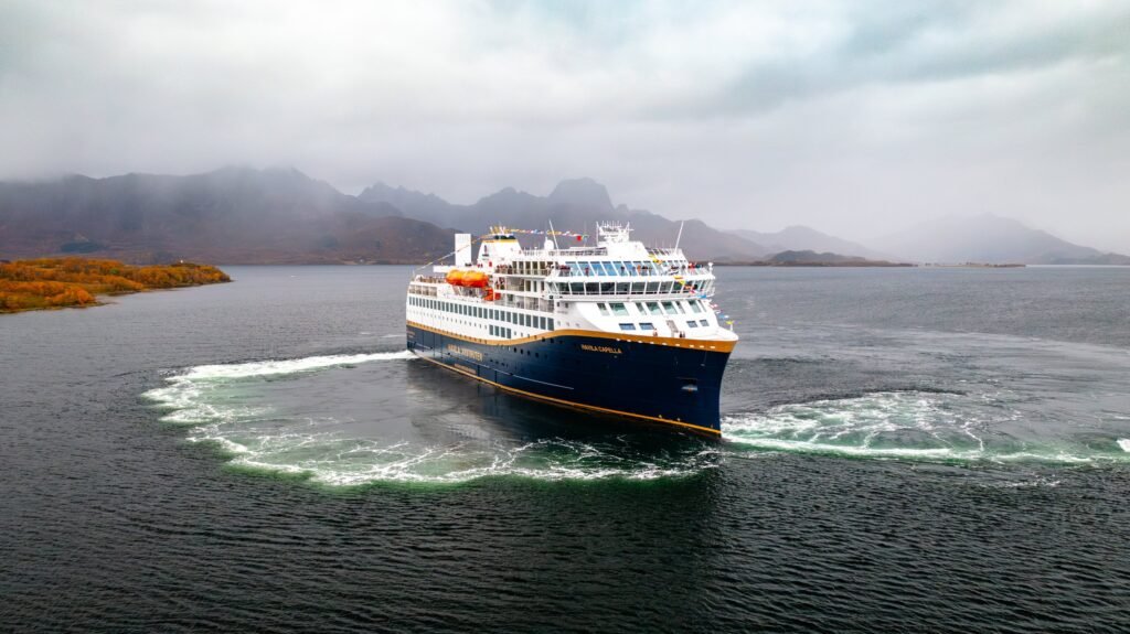 Havila Capella in Eidsfjorden, her name and Bergen–Kirkenes–Bergen route painted on the hull