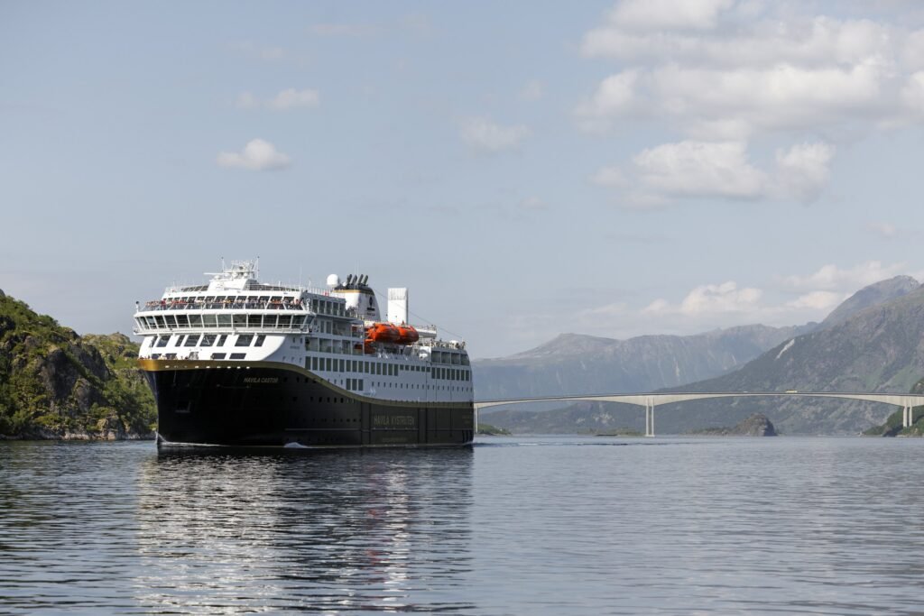 Havila Castor with passengers on the open deck, her name on the bow