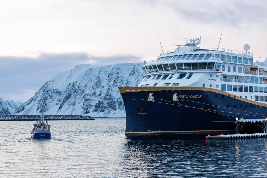 Havila Castor at Honningsvåg, snow on the hills behind
