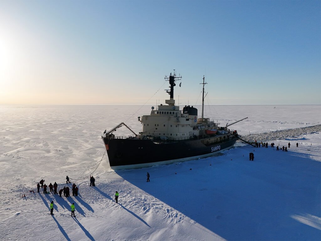 Guests floating in the ice in red survival suits beside the Sampo icebreaker, Kemi — view 3
