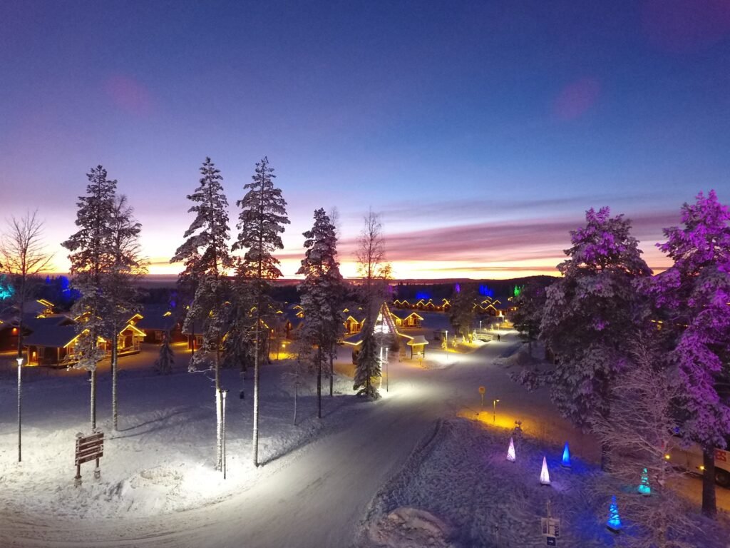 Santa Claus Holiday Village at dusk, its lit cottages seen from the air