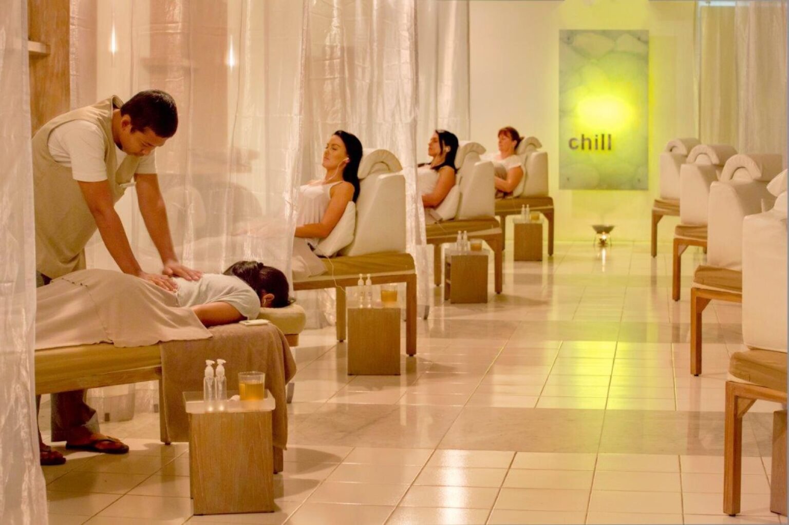 A reflexology room with reclining chairs in a row.