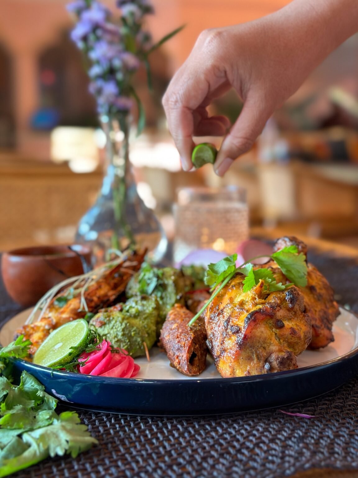 A plated Indian tandoor dish on a dark table setting.