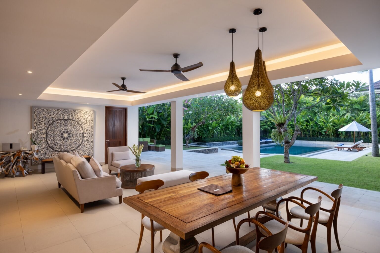A dining table with pendant lights, open to the garden on one side.