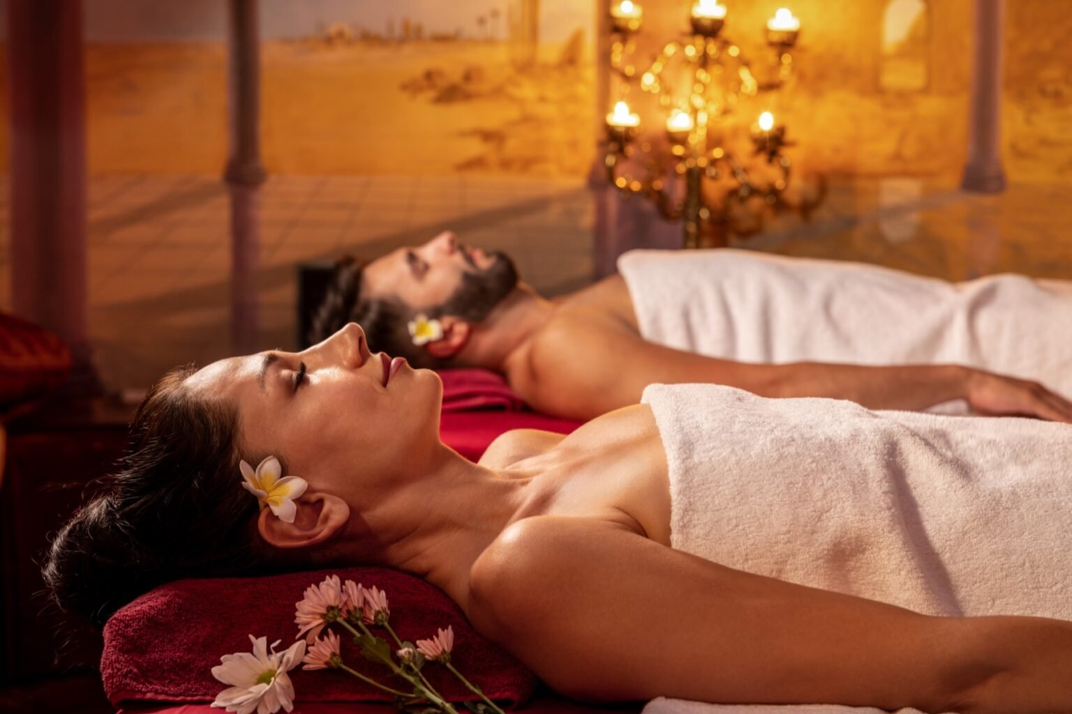 A spa treatment room set up with two massage beds side by side.