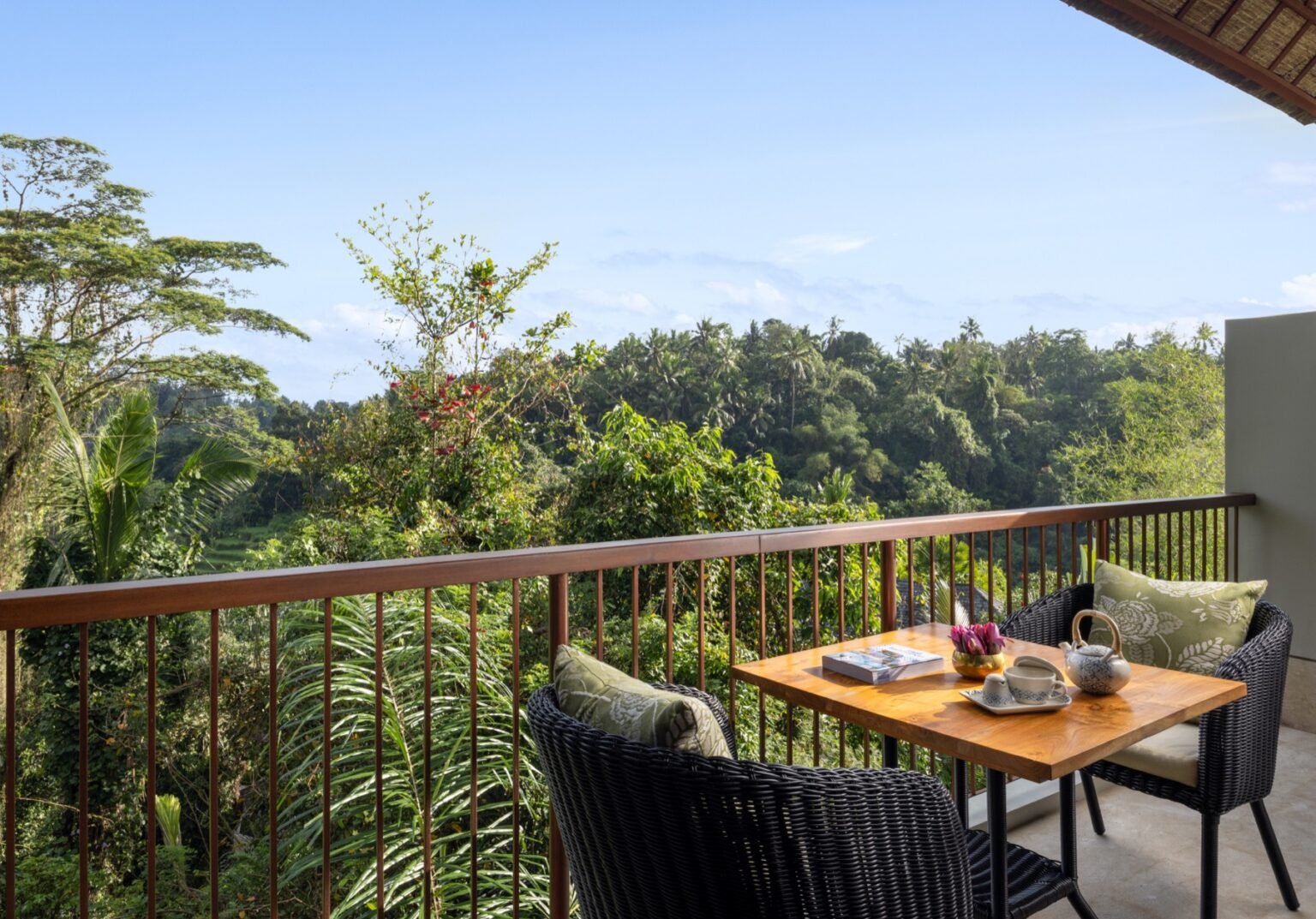 A balcony table and chairs set for two above the jungle valley.