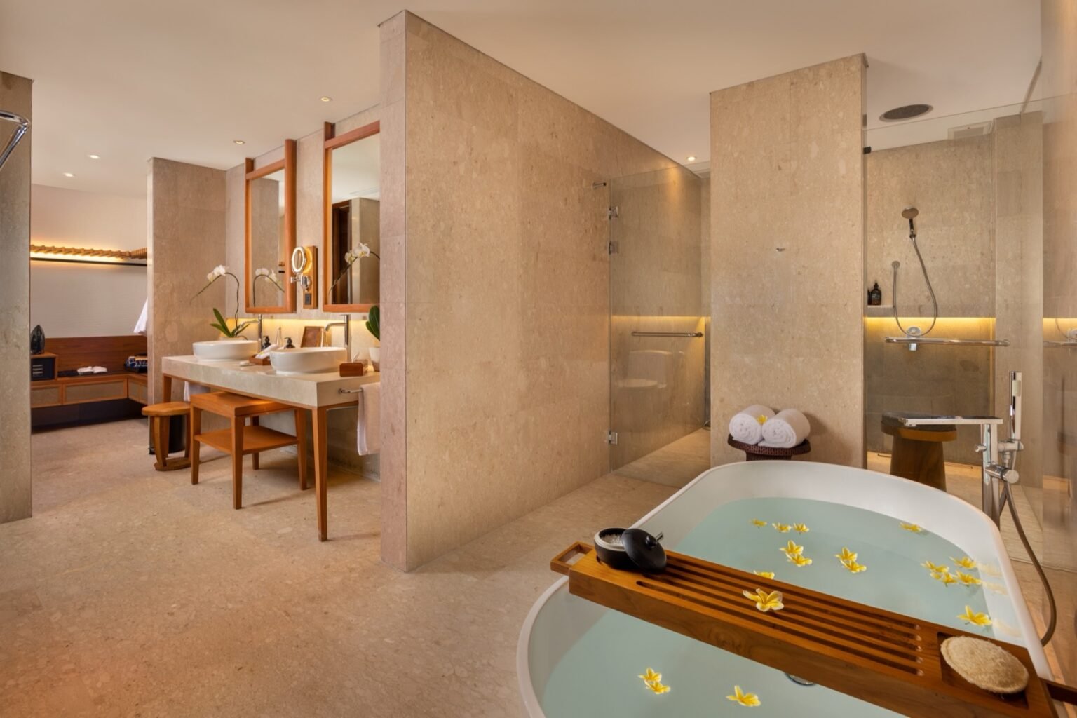 A bathroom with twin basins and a bath.