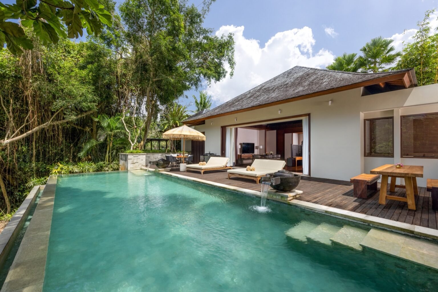 A two-bedroom villa with a private pool and a covered living area beside it.