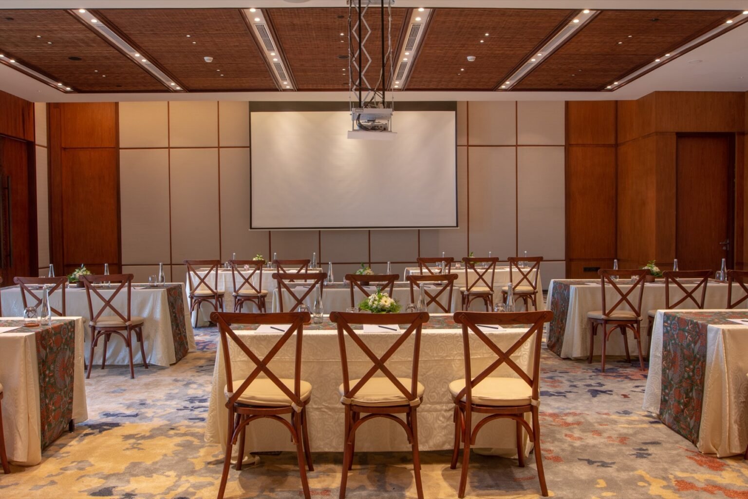 A function room laid out classroom style with rows of draped tables and chairs.