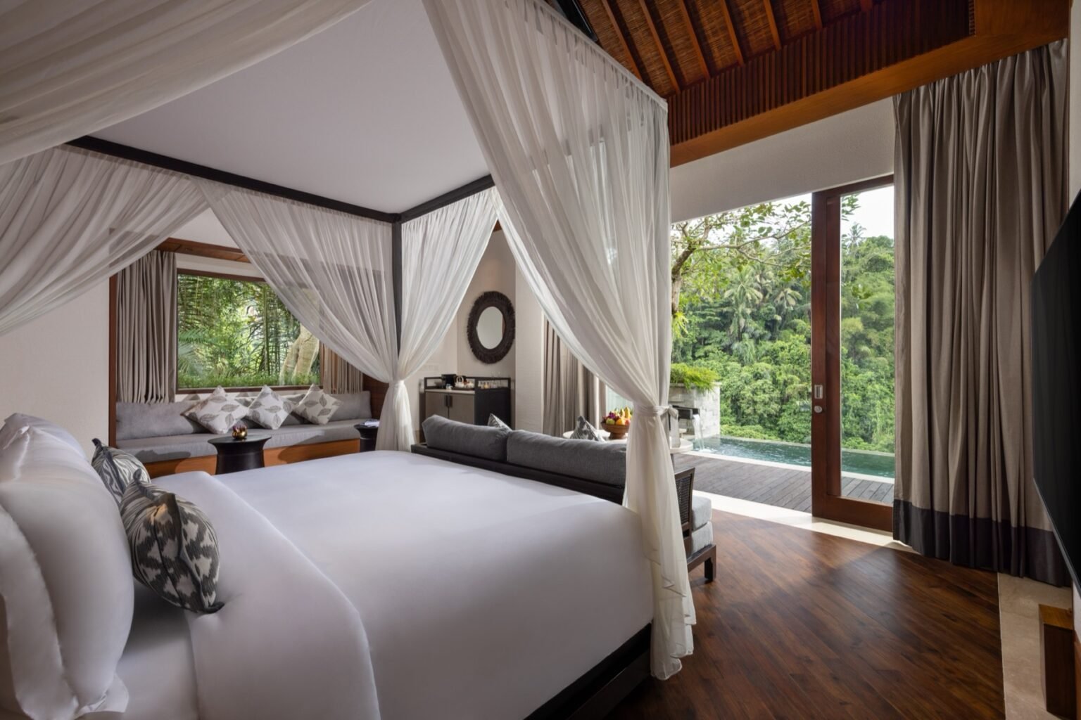 A large villa with a private pool, sun loungers and a pavilion under jungle canopy.
