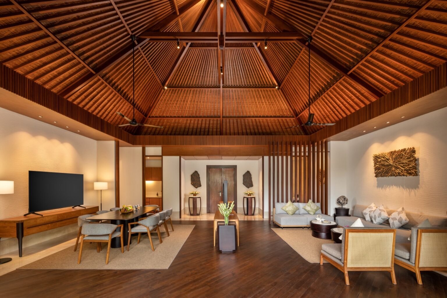 A villa living room with sofas opening onto the pool terrace.