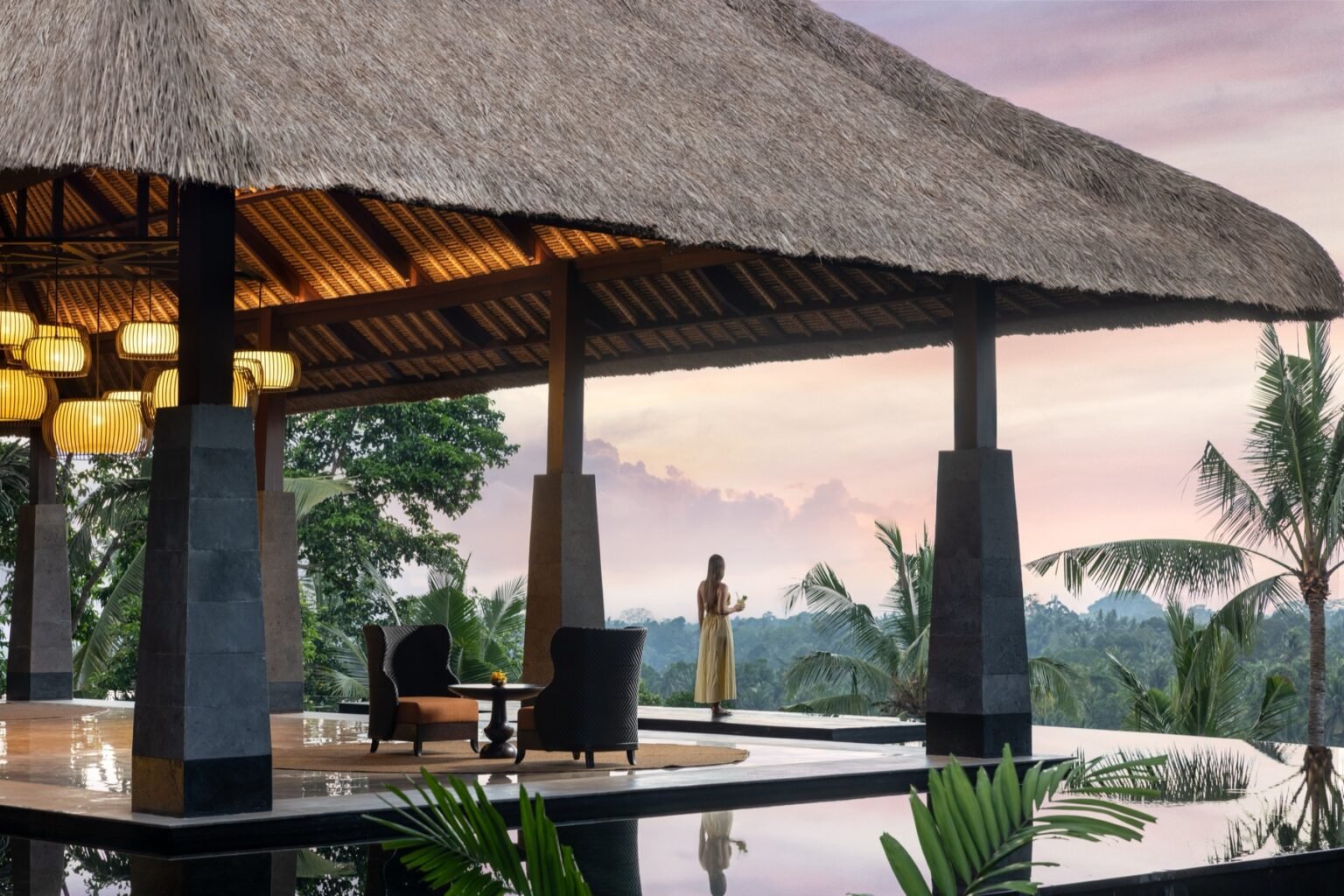 An open pavilion arrival lobby with a high thatched roof and timber columns.