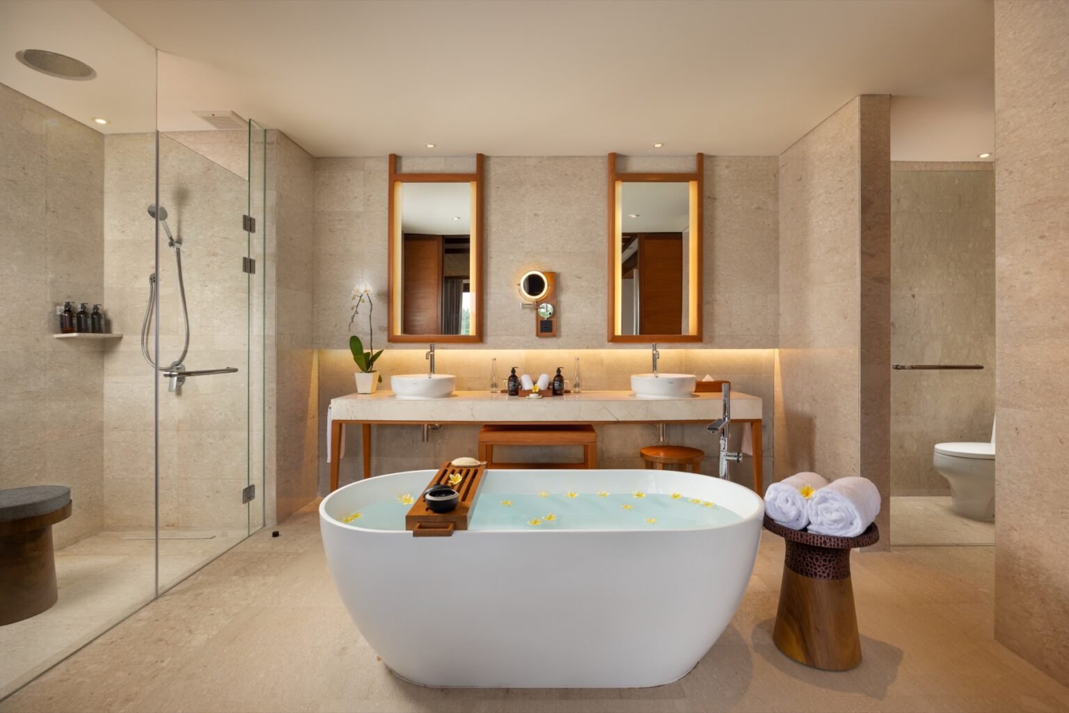 A bathroom with a freestanding oval bath, twin basins and a walk-in shower.