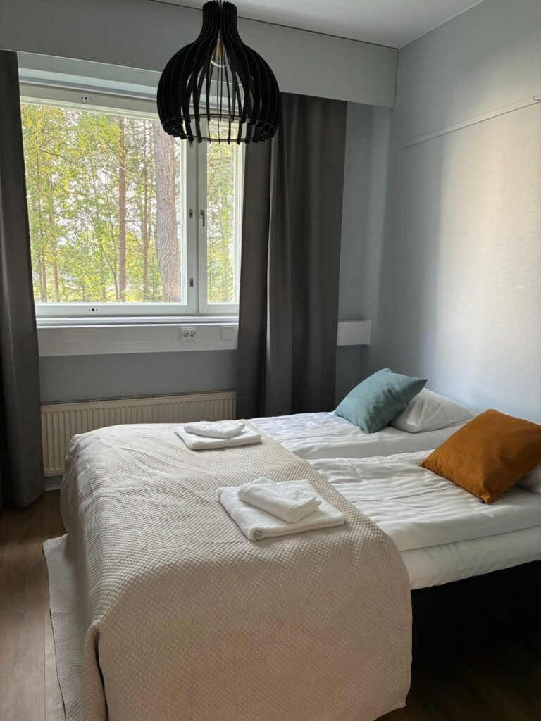 A twin room at the boutique hotel in Kemijarvi, with a window onto the trees
