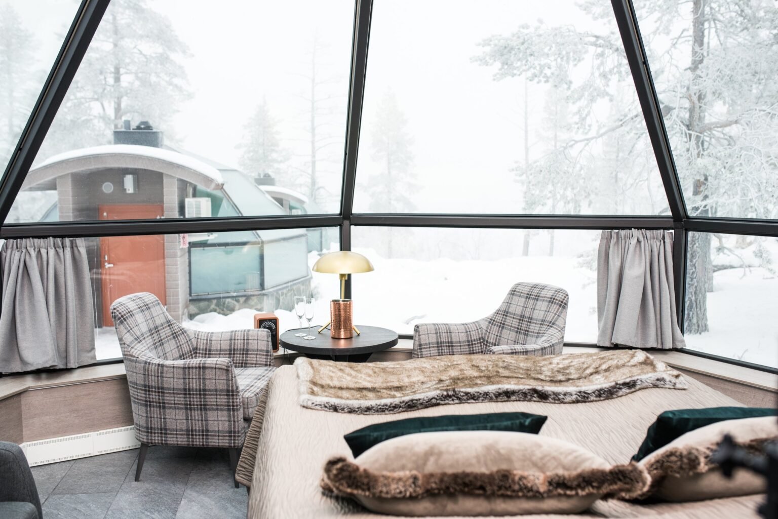 Inside a glass igloo, bed beneath the glass roof — Levin Iglut – Golden Crown, Levi