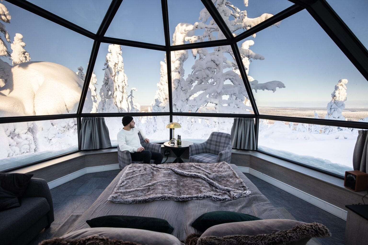 Inside a glass igloo, bed beneath the glass roof — Levin Iglut – Golden Crown, Levi