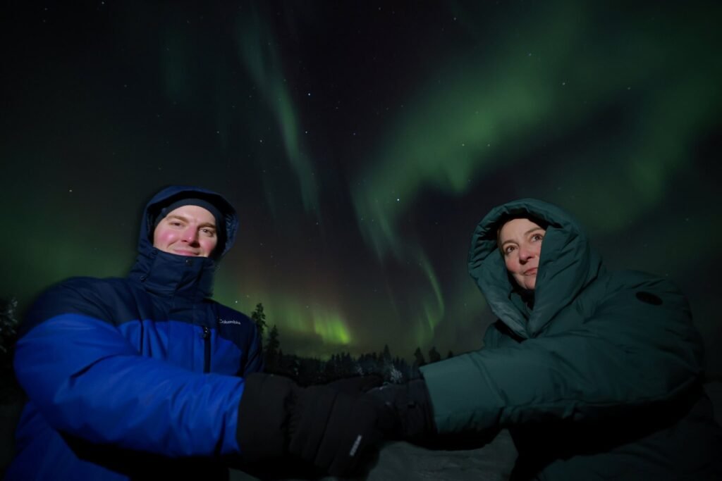 The northern lights over snow-covered forest in Lapland