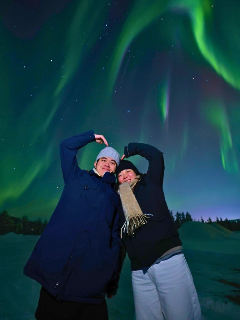 The northern lights over snow-covered forest in Lapland
