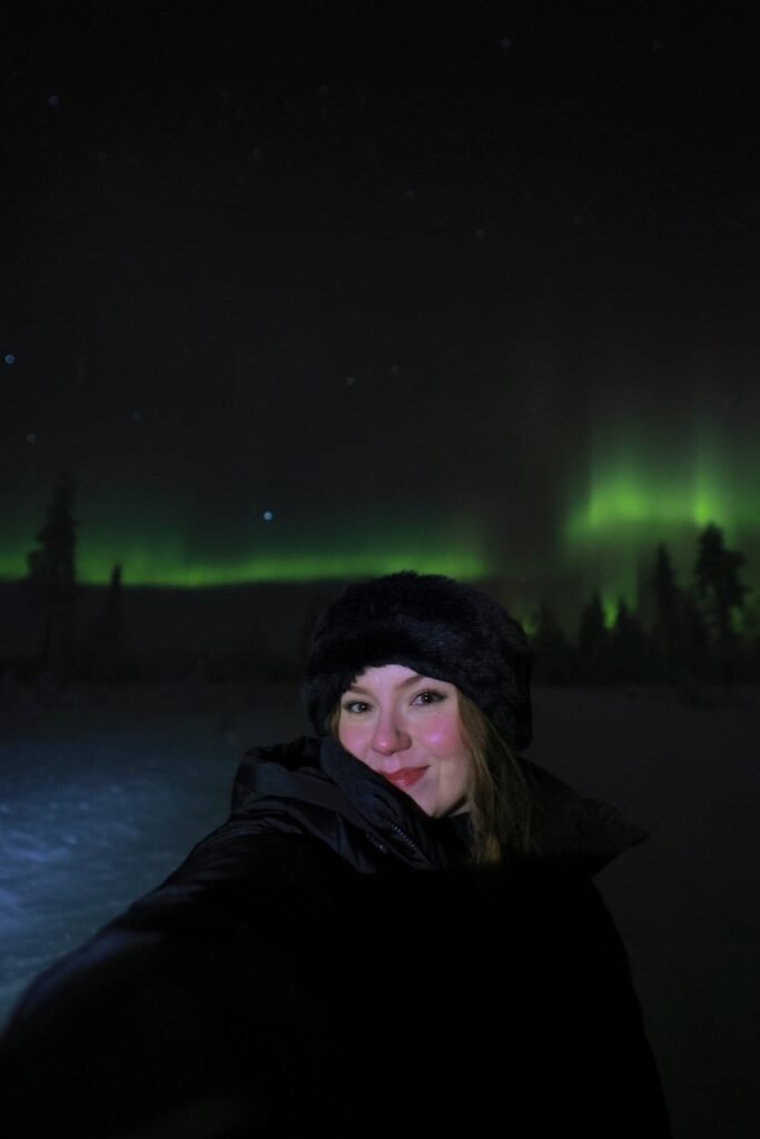 The northern lights over snow-covered forest in Lapland