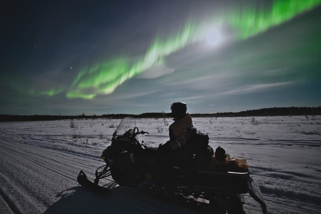 A snowmobile parked under the northern lights