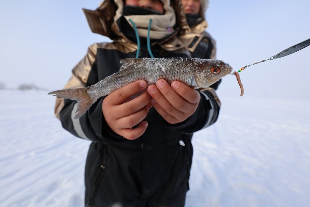 Ice fishing on a frozen lake in Lapland