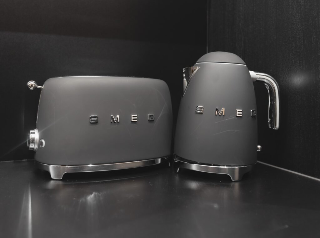A kettle and toaster on a dark stone kitchen counter
