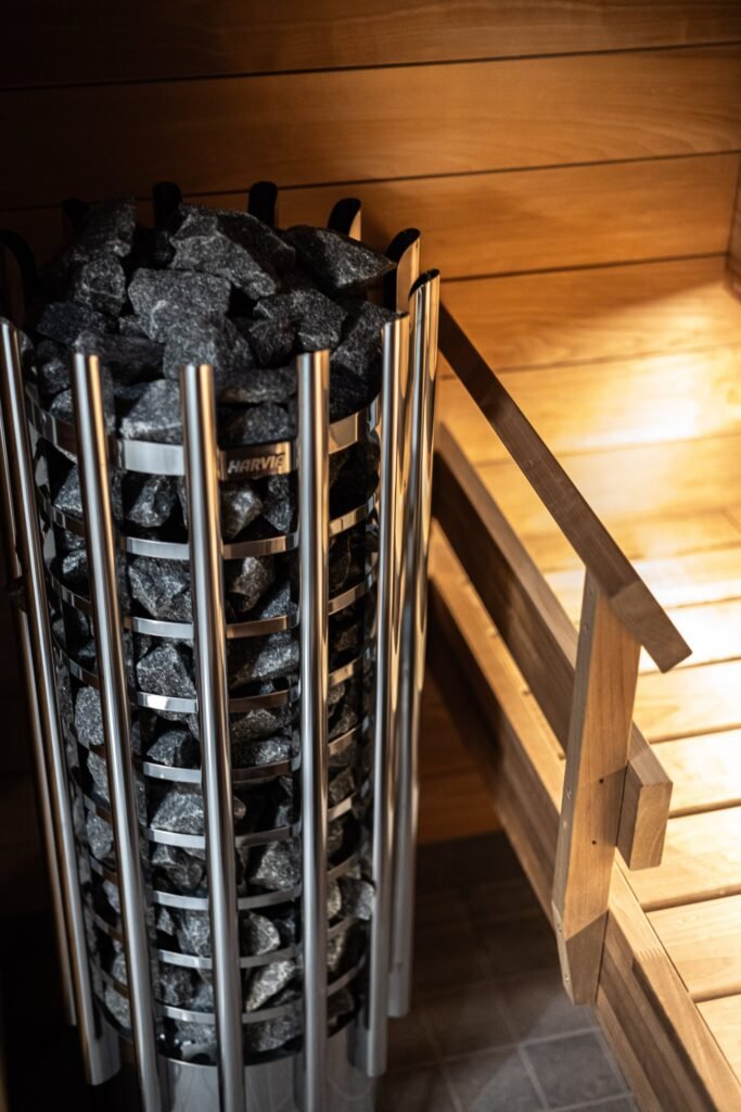 A sauna heater stacked with stones beside timber benches