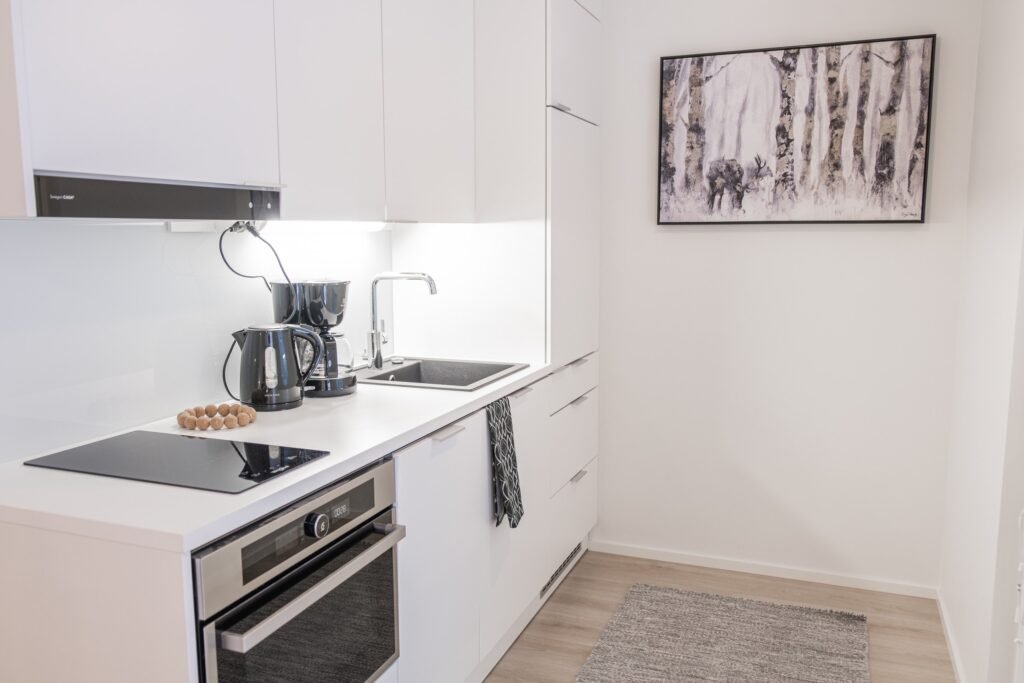 A fully equipped kitchen in a studio apartment in central Rovaniemi, with an oven, hob, kettle and coffee maker
